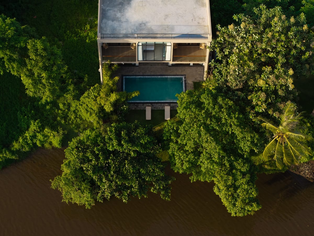 The hotel and its pool nestled in greenery on the riverbank